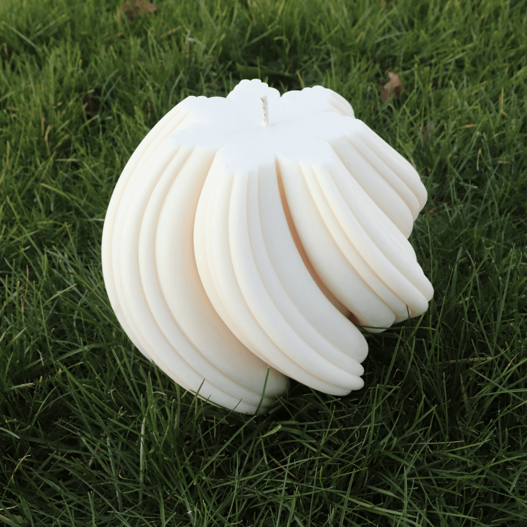 Large Snowflake Swirl candle showcasing a unique design, placed on grass for an eco-friendly ambience.