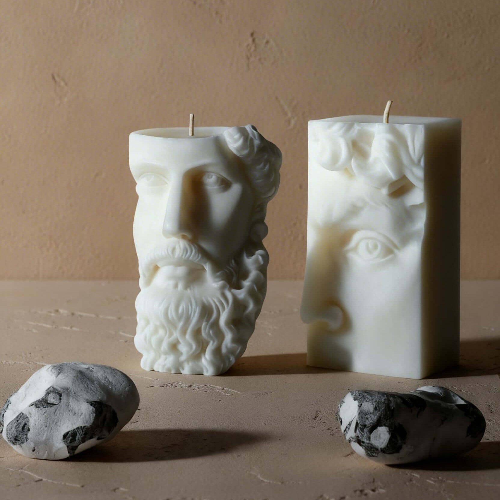 Two sculptural candles on a stone table