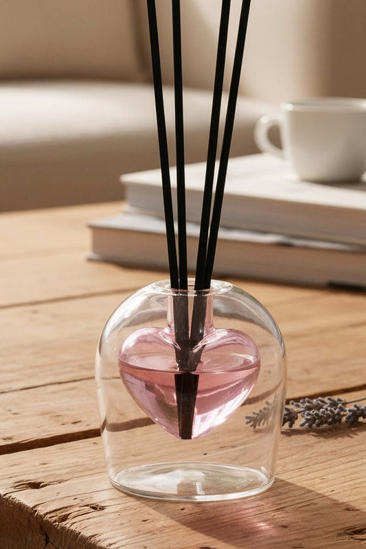 Diffuser with sticks on a wooden table in a cozy living room setting