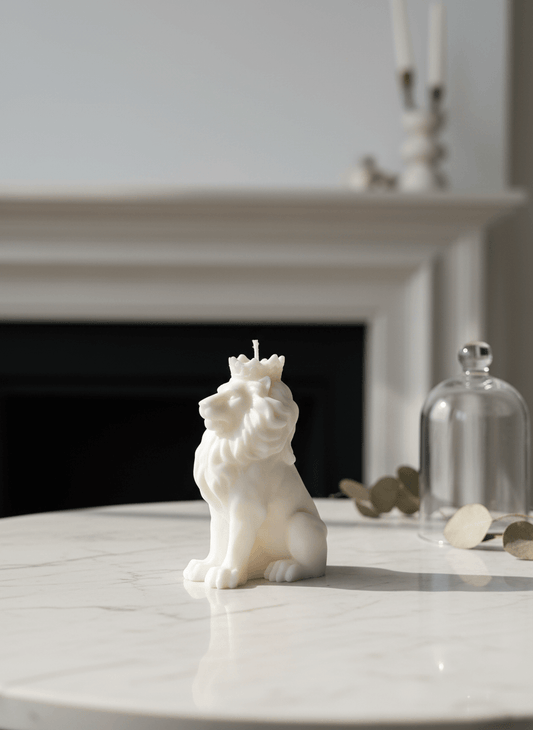 White lion-shaped candle on a marble surface with a fireplace in the background